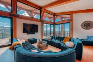 a living room with blue couches and windows at Stunning Luxury Family Home Near Zion National Park in Orderville +84 photos