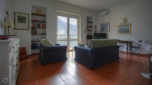 ein Wohnzimmer mit zwei Stühlen und einem Fenster in der Unterkunft Regina Nuova 13 in Laglio