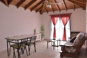 a living room with a table and chairs and a couch at Casa Amapola in Trelew