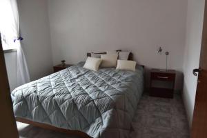 a bedroom with a large bed with two pillows at Casa Amapola in Trelew
