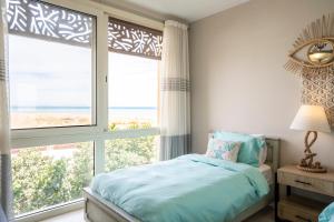 Postel nebo postele na pokoji v ubytování Mangroovy Seafront condo - Great Kite Surfing