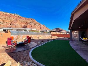 カナブにあるLuxury Kanab Utah Family Home with Amazing Views Pool Gymの家の前の緑の芝生のある庭