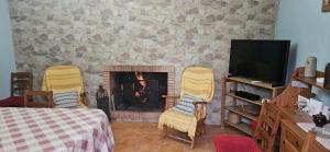 a living room with two yellow chairs and a fireplace at Casa Rural Parajes del Chanza in Cortegana
