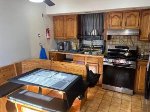 a kitchen with wooden cabinets and a stove top oven at The Evergreen 14 guests up to 16 25 min from NYC in Bayonne +9 photos