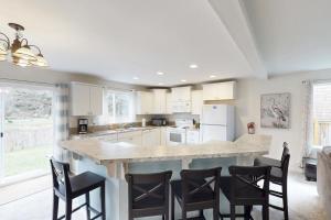 a kitchen with a large island with bar stools at Lighthouse By The Cove in Seaside