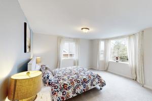 a bedroom with a bed and a table and a window at Lighthouse By The Cove in Seaside