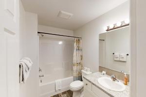 a white bathroom with a sink and a toilet at Lighthouse By The Cove in Seaside +22 photos