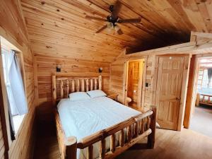 een slaapkamer met een bed in een houten hut bij Deluxe Cabin7 Within Campground in Mifflinburg +22 foto's