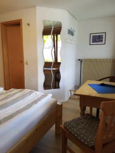 a bedroom with a bed and a desk and a table at Haus Am Tannenhain in Titisee-Neustadt
