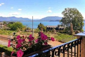 a balcony with flowers and a view of the water at La dimora del lago in Meina