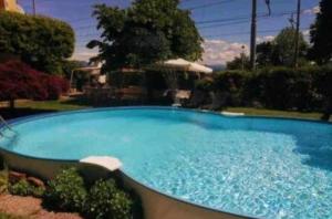 a large blue swimming pool in a yard at La dimora del lago in Meina
