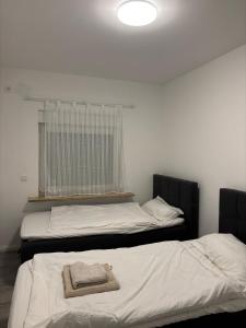 two beds in a room with a towel on them at TopLageEG in Augsburg