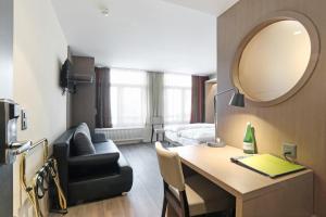 a hotel room with a desk and a mirror at Boutique Hotel St. Georg in Einsiedeln