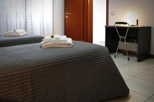 two beds in a room with a desk and a chair at B&B Il Sasso Antico in Verona