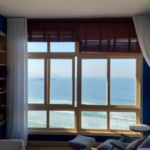 una grande finestra con vista sull'oceano di Uma estadia Sobre as Ondas a Guarujá