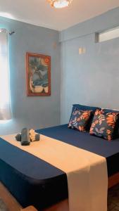 a bed in a room with a blue wall at Suites Estrela Dalva in Lauro de Freitas