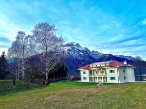 a house in a field with a mountain in the background at CORTE dei SANTI suite in Lèvego +24 photos