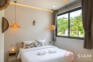 ein Schlafzimmer mit einem Bett und einem großen Fenster in der Unterkunft Villa Toi&Moi 3Br Private Pool Sea View in Ban Thung + 19 Fotos