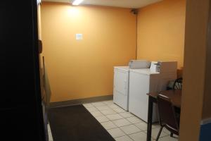 a small room with a white refrigerator and a table at Extended Stay Warrenton Inn in Warrenton