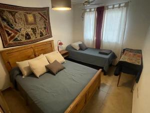 ein Schlafzimmer mit zwei Betten und einem Tisch und einem Fenster in der Unterkunft Casa con pileta Aeropuerto Circunvalación Kempes Quorum Siglo 21 in Cordoba