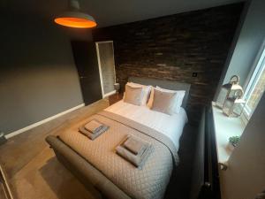 a bedroom with a bed and a brick wall at The TAY in Melrose