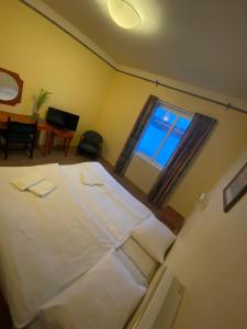 a bedroom with a large white bed with a window at Hotell Indalsleden in Bispgården