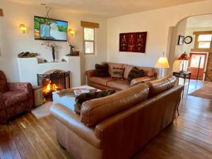 a living room with leather couches and a fireplace at Cozy Historic Family Home in Downtown Kanab Pet Friendly in Kanab