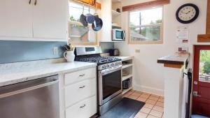 a kitchen with white cabinets and a stove top oven at Cozy Historic Family Home in Downtown Kanab Pet Friendly in Kanab +49 photos
