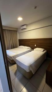 une chambre d'hôtel avec deux lits dans une chambre dans l'établissement Apartamento no Barretos Country Resort, à Barretos
