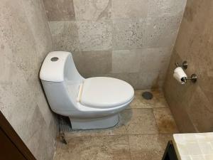 a bathroom with a white toilet in a stall at Departamento Cómodo in Cholula