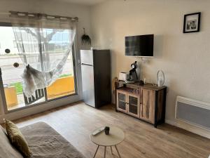a living room with a refrigerator and a table at T2 50m PLAGE BARCARES PORT RDC in Le Barcarès