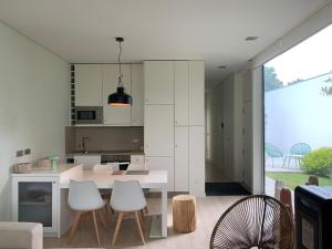 a kitchen with white cabinets and a table and chairs at Bisas Villa in Caminha