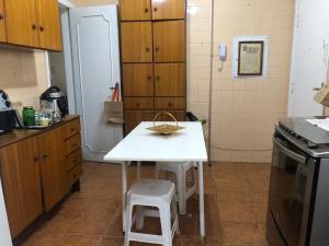 a small kitchen with a white table and stool at Quarto em apartamento in Sao Paulo