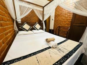 a bed in a room with a brick wall at Nivartana Villa and Purana Ayurveda Center in Bentota +68 photos
