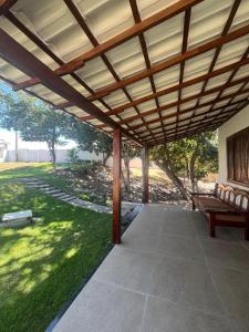a wooden pergola with a bench on a patio at Suíte Praia Seca in Araruama