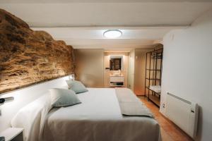 a bedroom with a large bed with a stone wall at Alojamiento rural la Mola 11 in Benasal