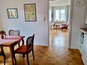 a dining room with a table and chairs and a living room at Ferienwohnung Dreierlei in Wasserburg am Inn