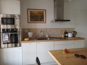 a kitchen with white appliances and a wooden table at Maison de vacances Ty Kornog in Pont-Aven +24 photos