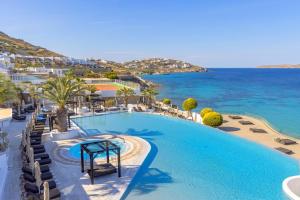 uma piscina com cadeiras e o oceano ao fundo em Saint John Hotel Villas & Spa em Agios Ioannis Mykonos mais 37 fotografias