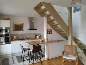 a kitchen with a wooden table and a staircase at Maison de vacances Ty Kornog in Pont-Aven