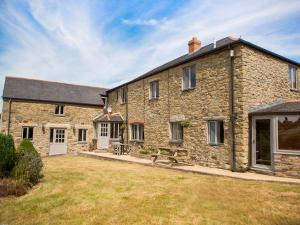 an exterior view of a stone house with a yard at Five Elements Farmhouse in Truro