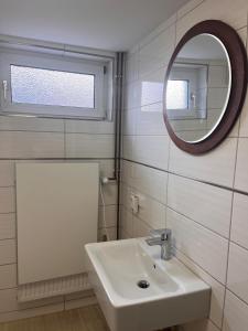 a white bathroom with a sink and a mirror at NR 2 EG 3 ZKB für Firmen und Familien in Vellmar