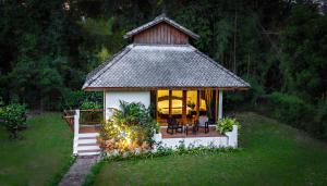 a gazebo with a table and chairs in the grass at The Hideaway Village in Ban Mae Hi