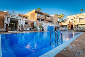 Una gran piscina en un complejo con edificios. en Chic apartment with great terrace, en Playa de las Américas