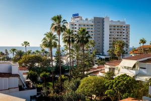 Una vista de una ciudad con palmeras y edificios. en Chic apartment with great terrace, en Playa de las Américas