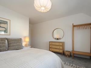 a bedroom with a white bed and a mirror at Wharfside in Penzance