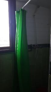 a green shower curtain in a bathroom with a window at Appartement Fascinant à Meknès in Meknès +11 photos