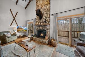 a living room with a stone fireplace and a couch at Southern Buffalo in Beech Mountain