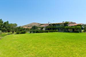 a large green field in front of a building at Villa Panorama in Moúdhros