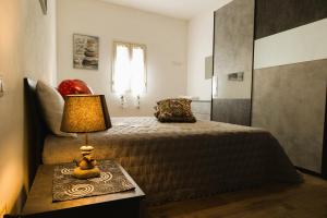 a bedroom with a bed and a lamp on a table at Sweet Home Pioppo in Pioppo